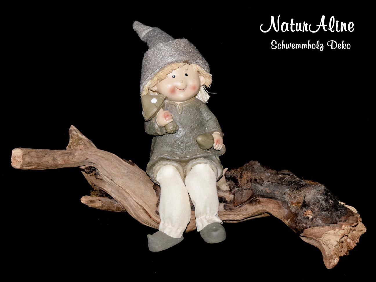 Schwemmholz mit Wichtelfigur, sitzt auf einem Holzstück, hält 2 Pilze